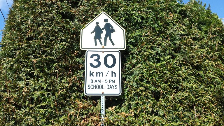 Volunteers remind drivers to slow down in school zones