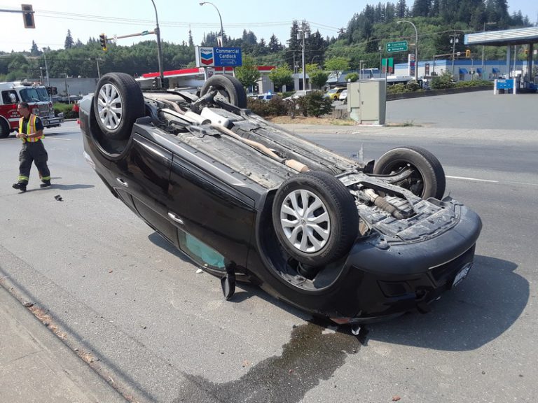 One injured after car runs red light, flips SUV
